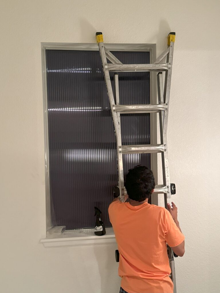 7 months in - Tackling the stairwell window... Bye-bye ugly blinds... hello fluted window film!
Pictured: Davis on a ladder doing the install.