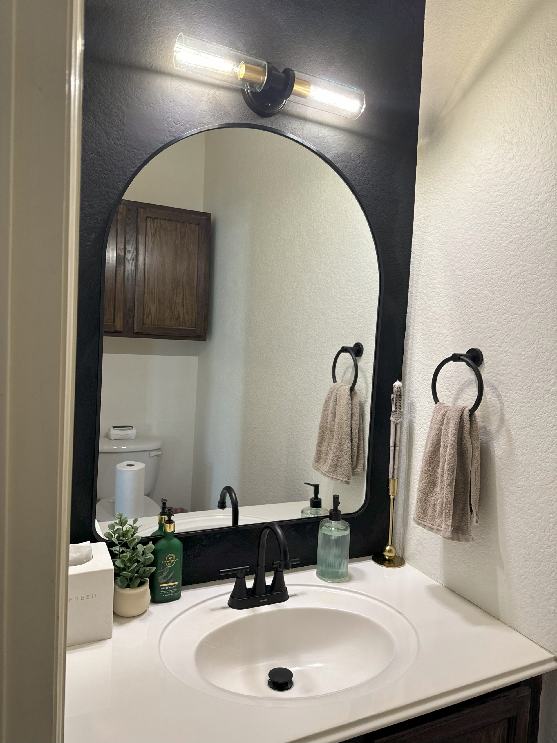Powder bathroom - DONE!
Black limewash accent wall... New black/brass light fixture... New arched mirror with black framing... NEW sing faucet and decor items.