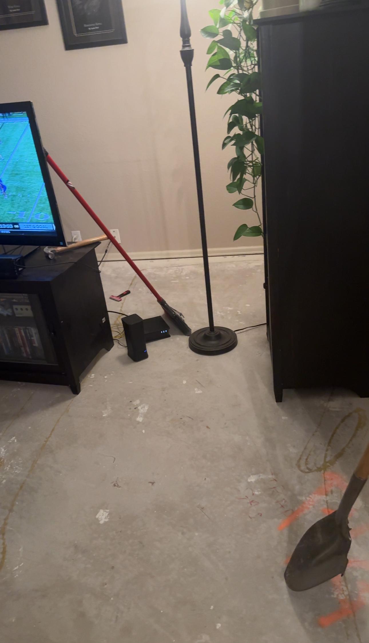 Day 1 - Carpet is gone, leaving only concrete floors.. A shovel is photobombing
